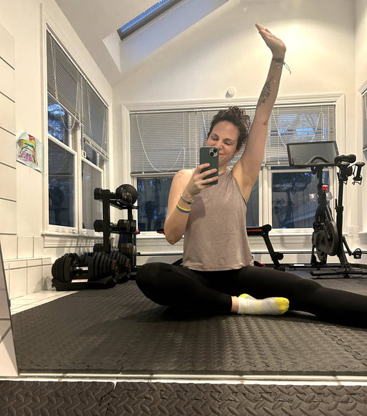 Woman sitting on the floor of her gym stretching